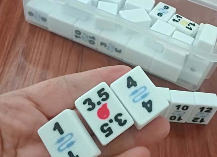 Set of dice with numbers and symbols, held by a hand, with a clear container in the background.